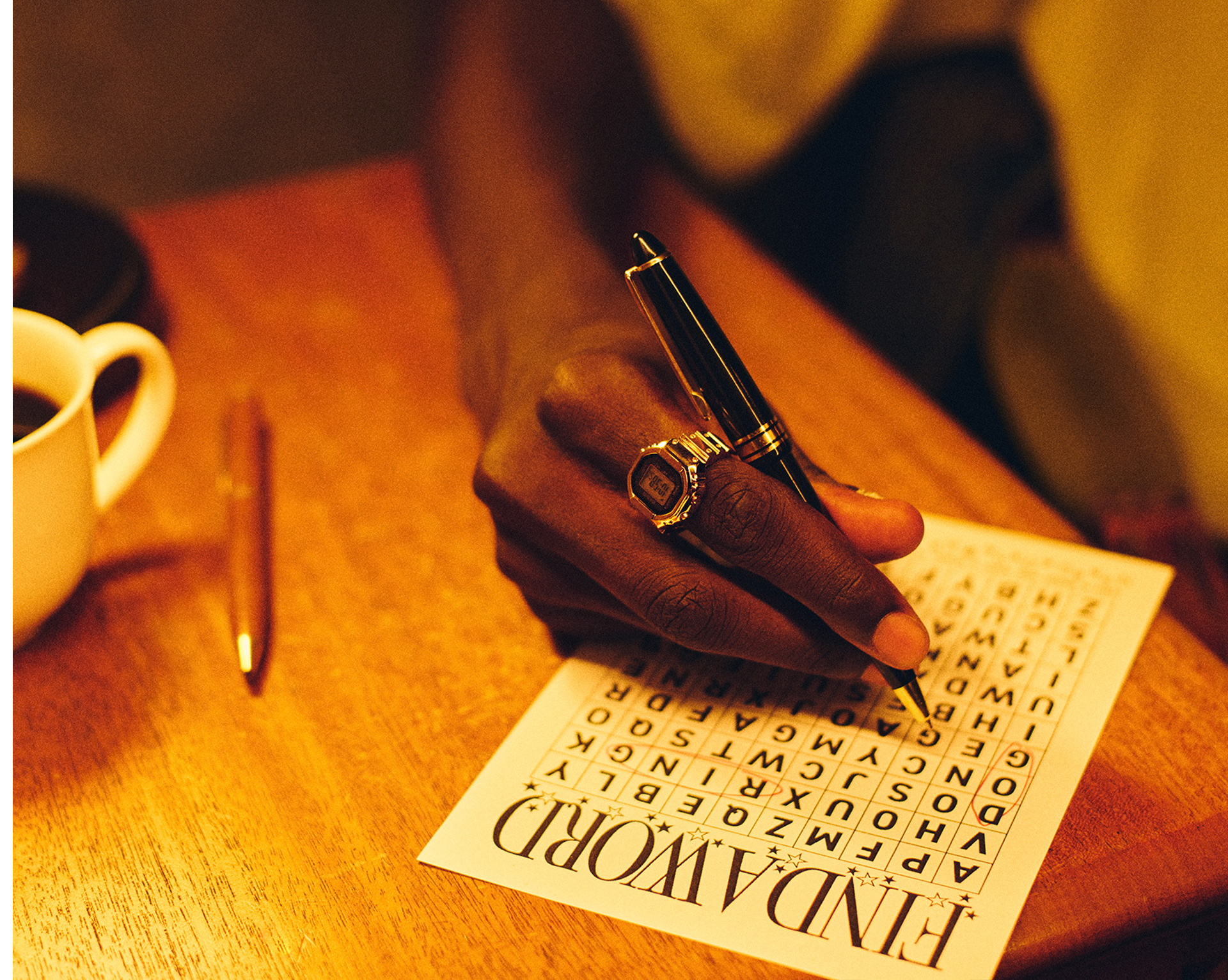Photo of a man wearing CRW-001G on his finger and solving a puzzle.