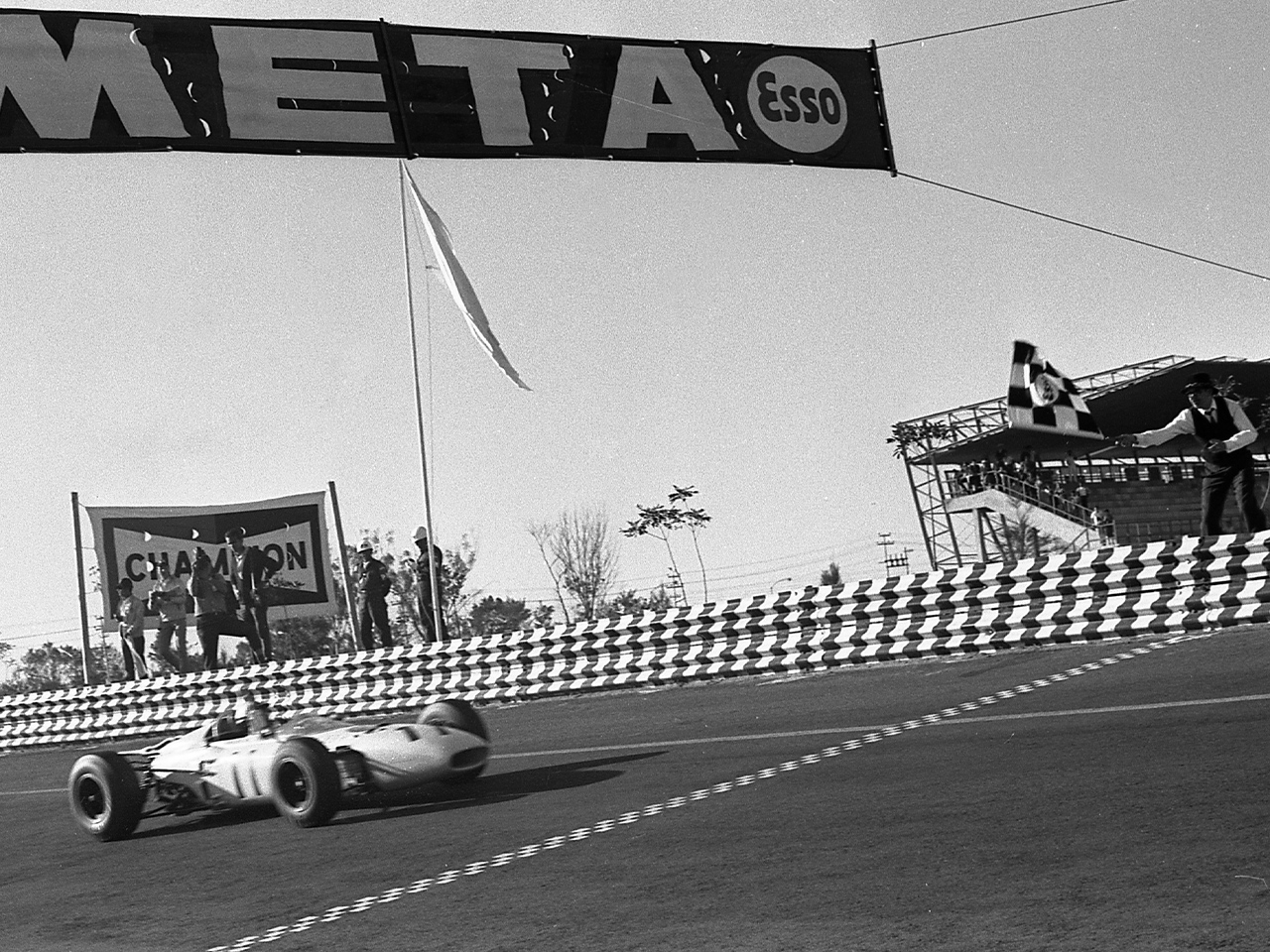 A photograph of Honda receiving the checkered flag in October 1965.